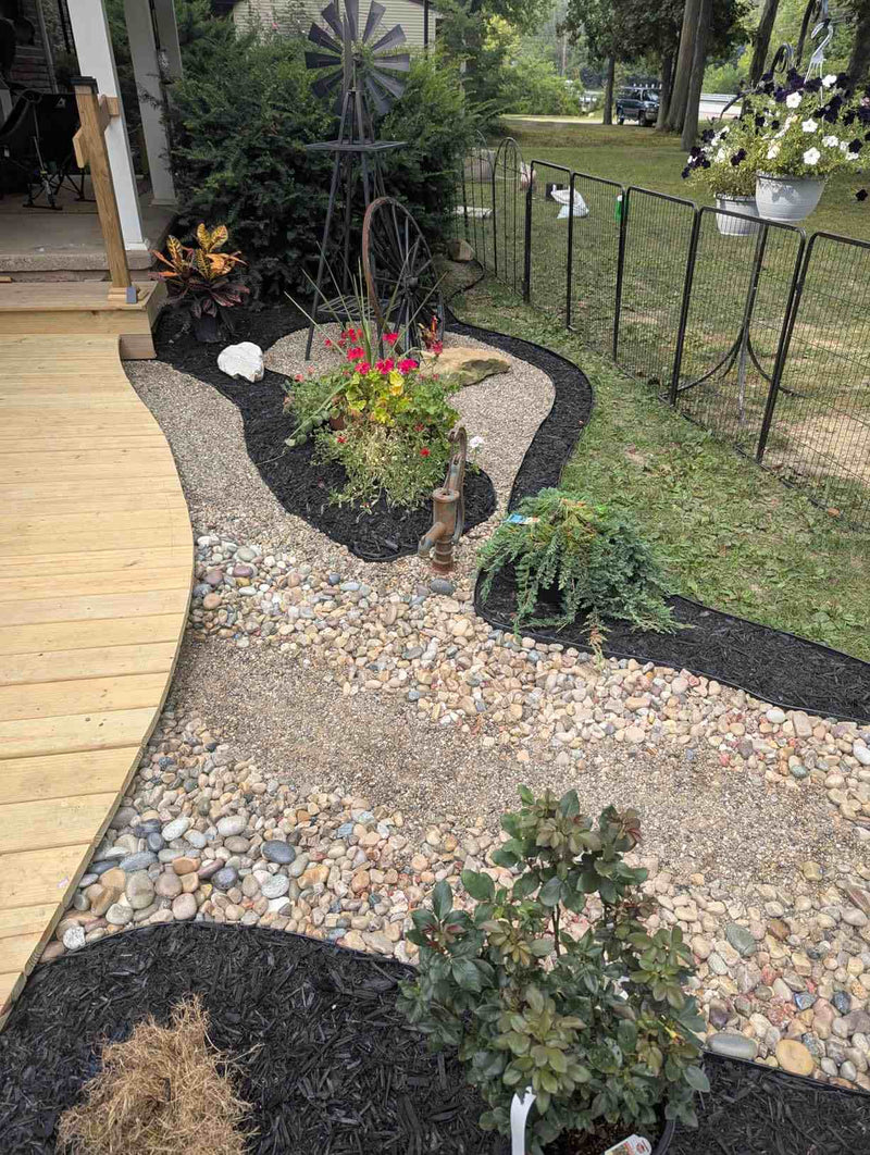 Amazon customer review mentioning Shabebe Mulch Glue holding strong on pea gravel with two coats of a 50/50 water mix, with a third coat planned for extra hold.